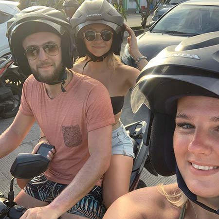 Group photo of helmeted bike drivers and passengers on the streets of Bali Group photo of helmeted bike drivers and passengers on the streets of Bali